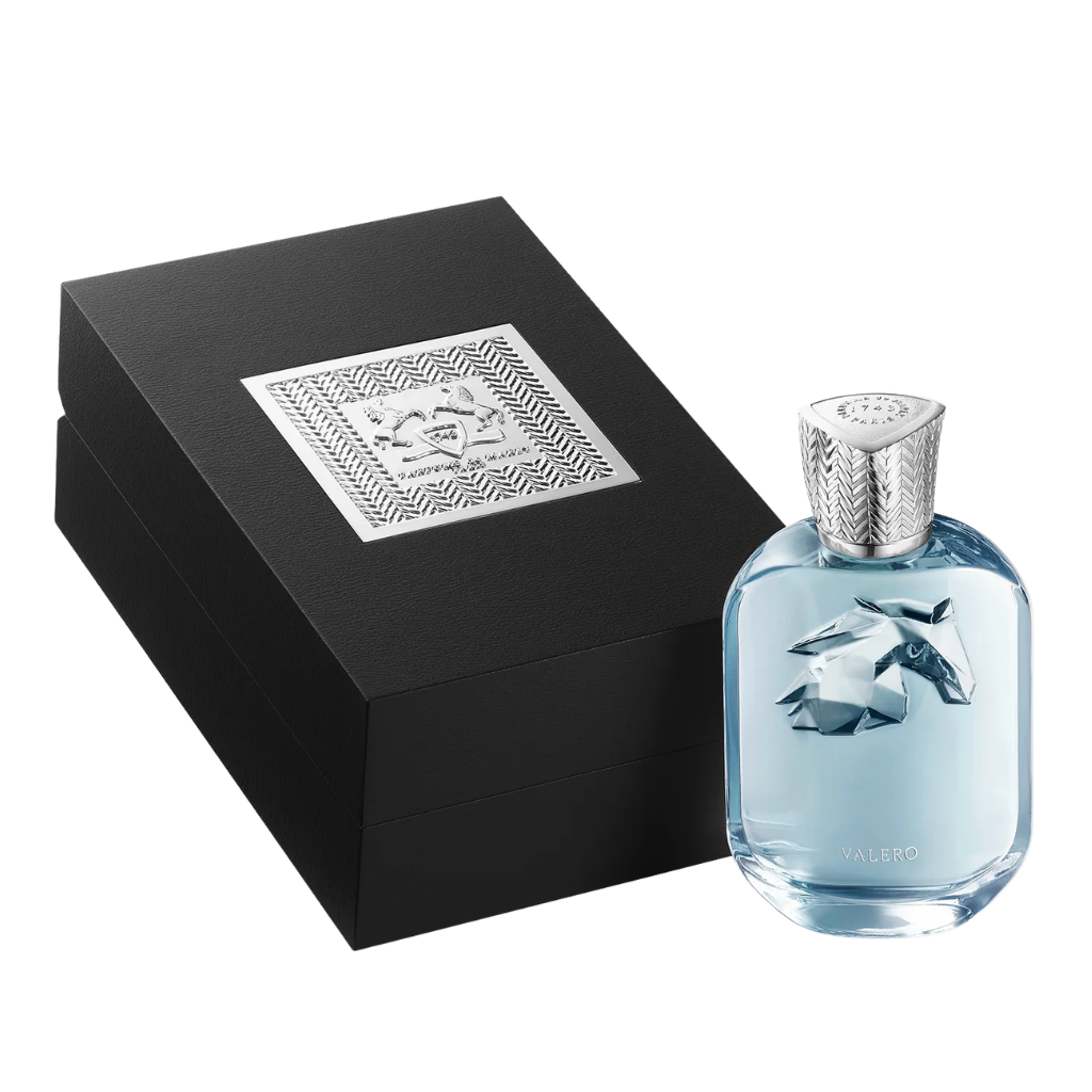 Valero Extrait de Parfum bottle with light blue liquid and decorative silver cap next to black luxury gift box